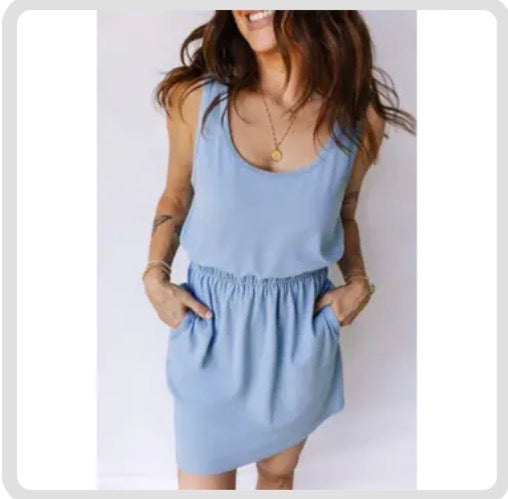 Woman wearing a light blue dress against a plain background